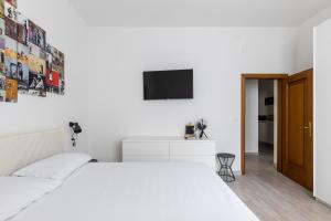 um quarto branco com uma cama e uma televisão em Modern apartment in Bologna by Wonderful Italy em Bolonha