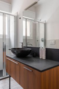 Modern apartment in Bologna by Wonderful Italy في بولونيا: حمام مع حوض أسود على منضدة