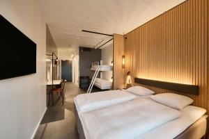 瓦埃勒的住宿－Zleep Hotel Vejle，卧室配有一张白色大床和一张书桌