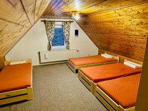 a attic room with two beds and a window at Pension Tony in Špindlerův Mlýn