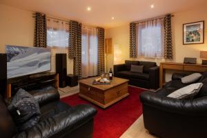 夏慕尼白朗峰的住宿－Chalet des Favrands，客厅配有皮革家具和平面电视