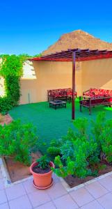 a patio with two benches and an umbrella at Villa Mans 2 in AlUla