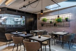 restauracja ze stołami i krzesłami w pokoju w obiekcie Stay COOPER l CITY LOFT w mieście Bolzano