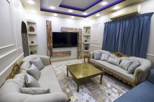 a large living room with couches and a tv at Villa Mans 2 in Al-ʿUla