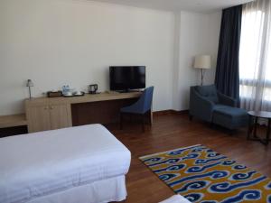 a hotel room with a bed and a desk and a chair at Osel Thimphu Bhutan in Thimphu