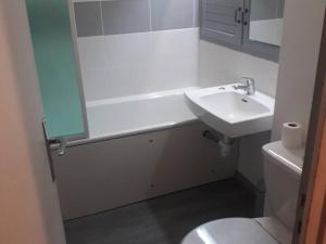 a bathroom with a sink and a tub and a toilet at Studio Arette, 1 pièce, 4 personnes - FR-1-602-14 in Arette