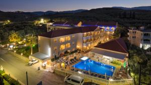 una vista aerea di un hotel con piscina di notte di Kozanos Suites with Private Pool ad Amoudi