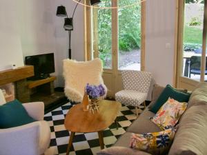 ein Wohnzimmer mit einem Sofa und einem Tisch in der Unterkunft Gîte du vieux chêne - 6pers. - Jardin arboré in Ault