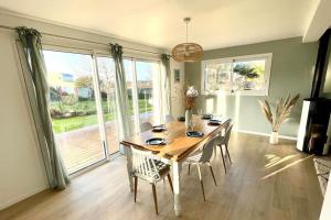 a dining room with a wooden table and chairs at Maison à l'orée du bois du Kador in Crozon