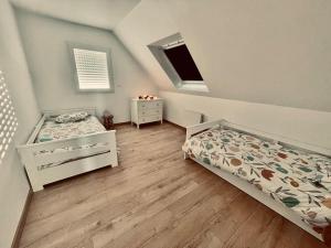 - une petite chambre avec 2 lits et une fenêtre dans l'établissement Maison à l'orée du bois du Kador, à Crozon