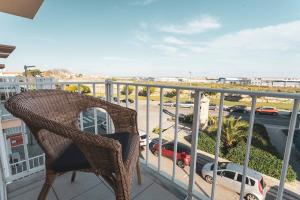 wiklinowe krzesło na balkonie z widokiem na parking w obiekcie Best Houses 13 - Peniche Great Location w mieście Peniche