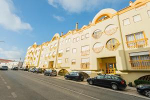 a row of cars parked in front of a building at Best houses 14: Close to the Beach Apartment in Peniche