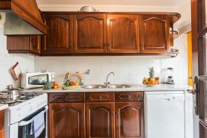 a kitchen with wooden cabinets and a sink at Best houses 14: Close to the Beach Apartment in Peniche