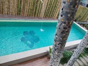 una piscina con una palmera al lado en Casa Herminia Baler en Baler