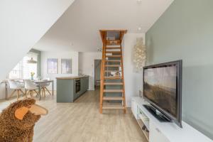 a living room with a tv and a ladder at Surf Break in Sankt Peter-Ording