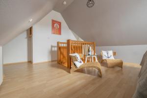 Zimmer mit einem Kinderbett, Stühlen und einem Tisch in der Unterkunft Surf Break in Sankt Peter-Ording