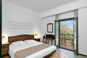 1 dormitorio con 1 cama y balcón en Erofili Beach Hotel, en Armenistis