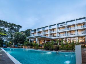 a hotel with a swimming pool in front of a building at WILD AVENUE RESORT & SPA in Thekkady