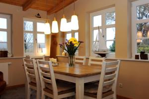 a dining room with a table with a vase of flowers at Krabbenkate in Prerow