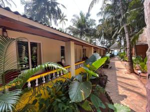 a building with trees and plants in front of it at Jardim a Mar in Agonda
