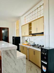 a kitchen with wooden cabinets and a black refrigerator at Milky Way Homestay Canggu in Canggu