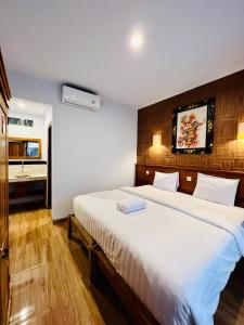 a bedroom with a large white bed in a room at Milky Way Homestay Canggu in Canggu