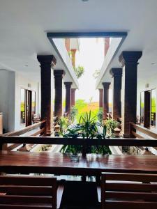 a dining room with a table and some columns at Milky Way Homestay Canggu in Canggu