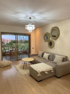 a living room with a couch and a table at Prestigia jade Marrakech ENTREE 191 APPARTEMENT 9 in Marrakech