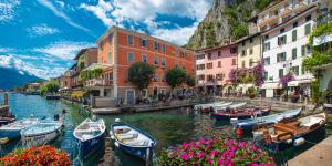 a group of boats in a canal with buildings and flowers at Limone DownTown in Limone sul Garda