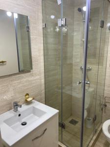 een badkamer met een wastafel en een glazen douche bij Prestigia jade Marrakech ENTREE 191 APPARTEMENT 9 in Marrakesh