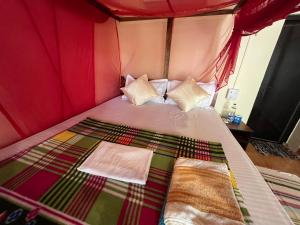 a bedroom with a bed with a red canopy at Jardim a Mar in Agonda