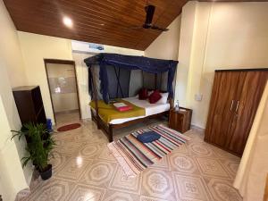 a bedroom with a bed with a blue canopy at Jardim a Mar in Agonda