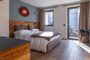 um quarto de hotel com uma cama, uma secretária e uma janela em Hotel Mon Émile em Aosta