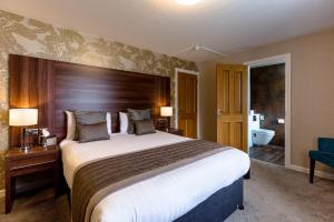 a hotel room with a large bed and a bathroom at The Melbreak Hotel in Workington +72 photos