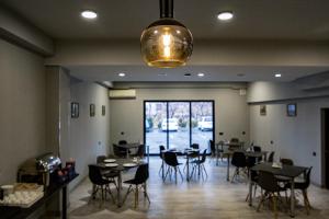 a dining room with tables and chairs and a large window at Inga Hotel Yerevan in Yerevan