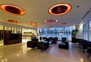 a lobby with chairs and tables in a building at Daiwa Roynet Hotel Hamamatsu in Hamamatsu