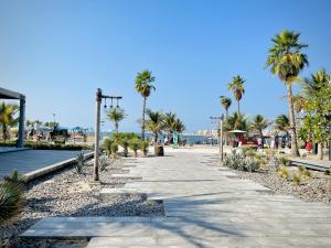 a sidewalk with palm trees and a beach at Royal Prestige Hotel in Dubai