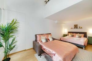 1 Schlafzimmer mit 2 Betten und einem Sofa in der Unterkunft DUPLEX LOFT IN LUGANO CENTER with Garden, Wi-Fi -By EasyLife Swiss in Lugano
