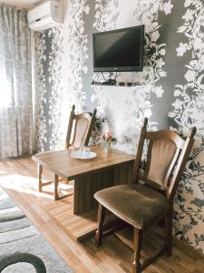 a dining room with a table and two chairs and a television at Koral Hotel in Verkhniy Koropets