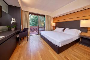 a hotel room with a large bed and a desk and a desk at Park Hotel I Lecci in San Vincenzo