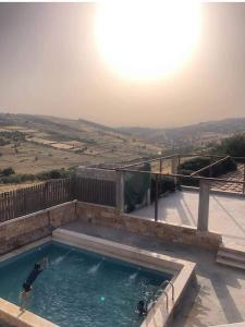 a man standing in a swimming pool on a house at Green house in Ajloun