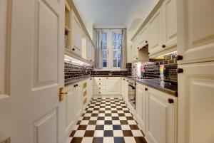 a kitchen with a black and white checkered floor at Southgarth Apartments by Week2Week in South Shields