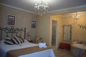 a bedroom with a bed and a bathroom with a tub at Pousada Hospedaria da Villa in Tiradentes