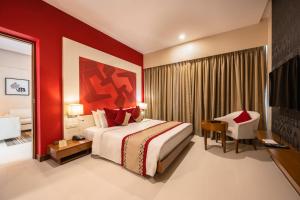 um quarto de hotel com uma cama grande e uma cadeira em The Fern Residency Mumbai em Mumbai