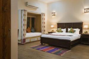 a bedroom with two beds and a mirror at Dev Garh in Jaisalmer