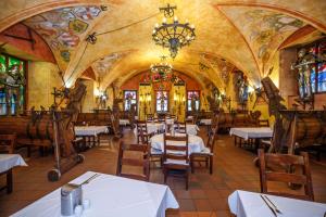 a restaurant with tables and chairs and a chandelier at Pytloun Old Armoury Hotel Prague, Stará Zbrojnice in Prague