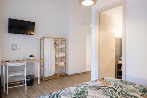 a bedroom with a bed and a desk and a table at Baronetto B&B in Cefalù