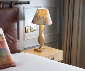 a lamp sitting on a night stand next to a bed at Castle Hotel by Chef & Brewer Collection in Leicester