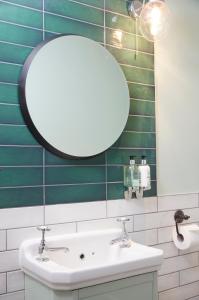 bagno con lavandino bianco e specchio di Castle Hotel by Chef & Brewer Collection a Leicester