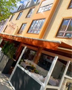 un restaurante con toldo frente a un edificio en Hotel Ristorante La Terrazza en Planegg